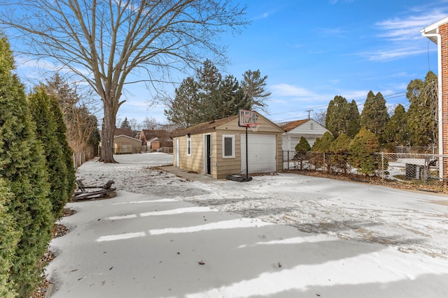 yard layered in snow featuring an outdoor structure and a garage