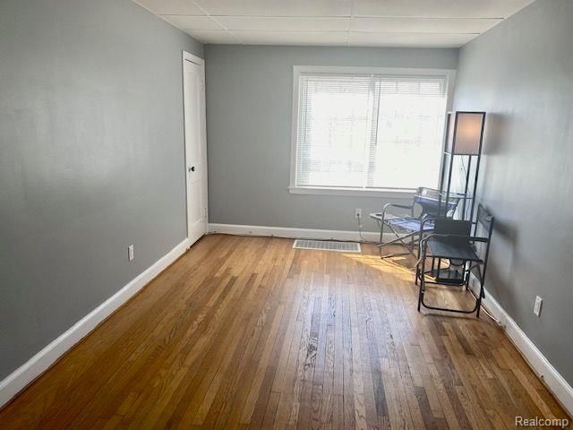 interior space with hardwood / wood-style flooring and a paneled ceiling