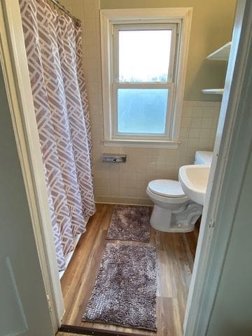 bathroom featuring hardwood / wood-style flooring, sink, tile walls, and toilet