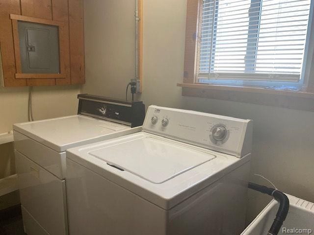 clothes washing area featuring electric panel and washing machine and dryer