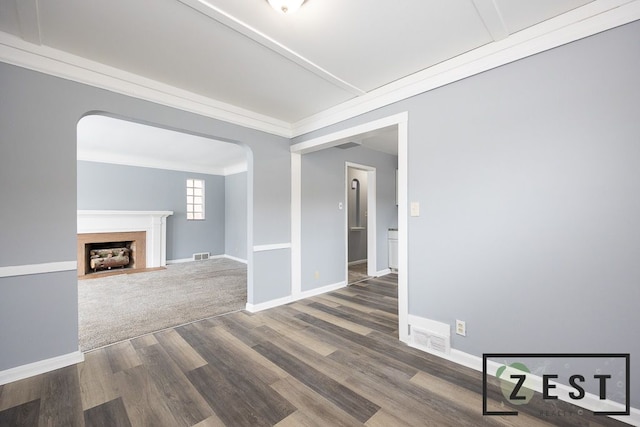 unfurnished living room with dark hardwood / wood-style flooring and crown molding