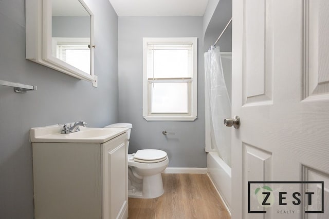 full bathroom with hardwood / wood-style flooring, vanity, shower / tub combo, and toilet