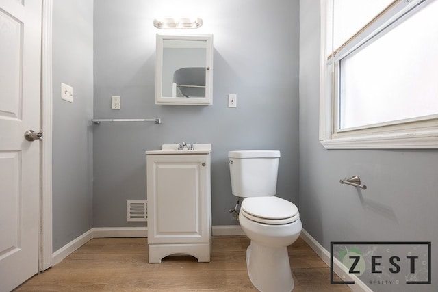 bathroom with hardwood / wood-style flooring and toilet