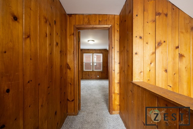 hall with carpet flooring and wood walls