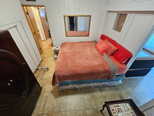 tiled bedroom featuring wooden walls