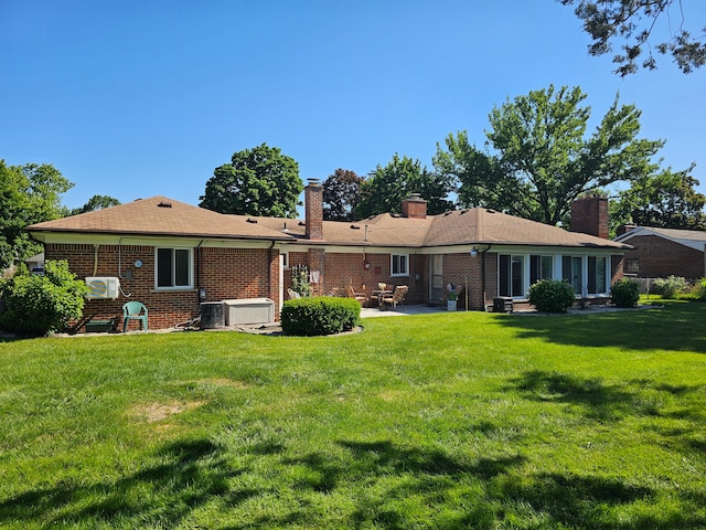 back of house with a patio area and a lawn