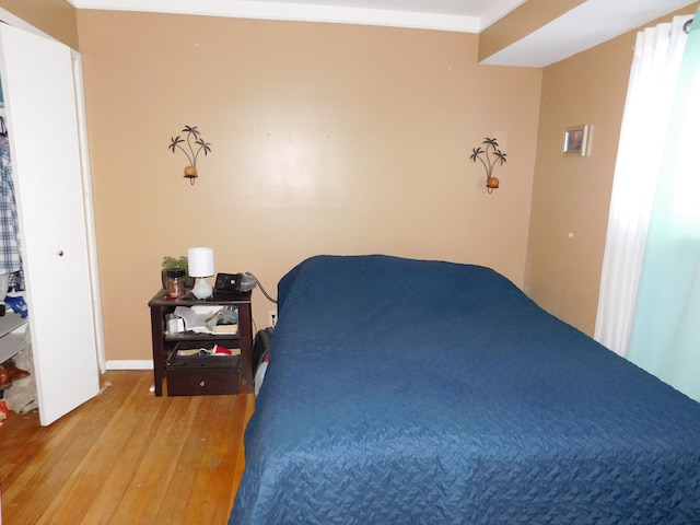 bedroom with hardwood / wood-style flooring and crown molding