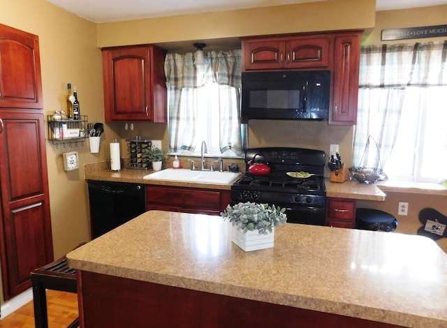 kitchen with sink, black appliances, and a healthy amount of sunlight