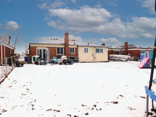 view of snow covered back of property