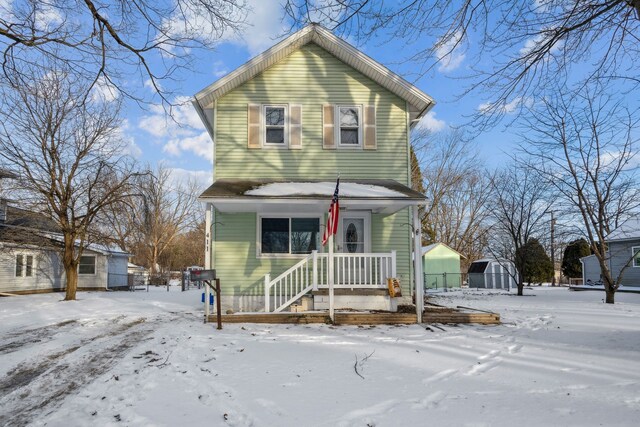 view of front property with covered porch and a storage shed