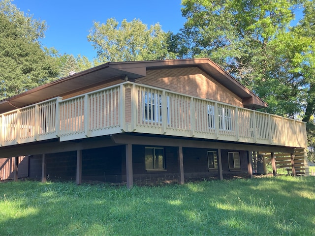 back of house with a deck and a lawn