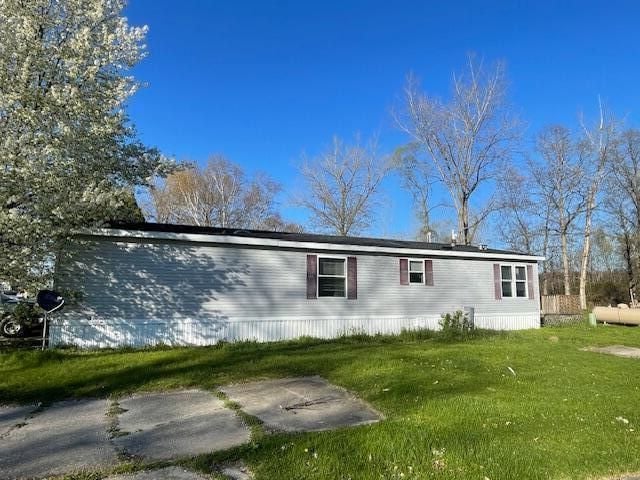 view of property exterior with a lawn