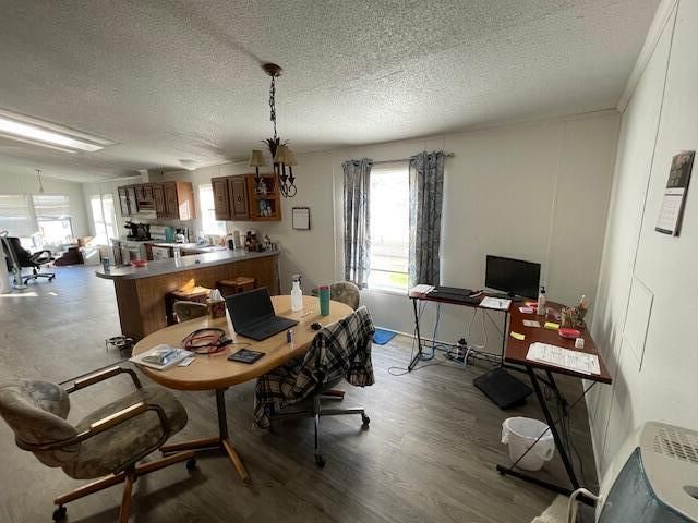 dining area featuring wood-type flooring and a textured ceiling