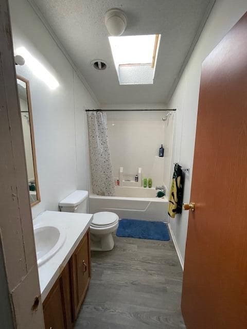 full bathroom featuring toilet, shower / tub combo, a textured ceiling, ornamental molding, and vanity