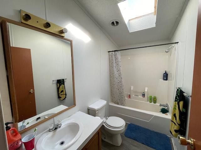 full bathroom with crown molding, toilet, shower / bath combination with curtain, and vanity