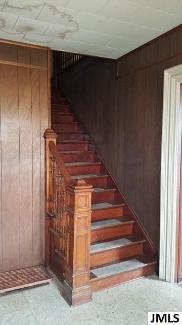 stairs featuring wood walls