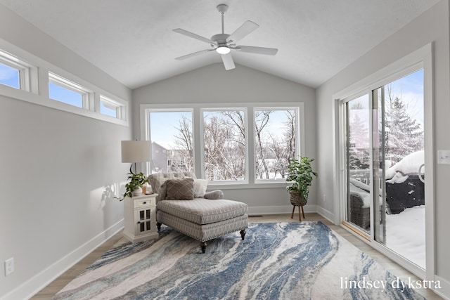 living area with baseboards, wood finished floors, a ceiling fan, and vaulted ceiling