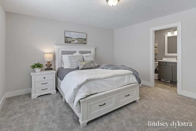 bedroom with connected bathroom, baseboards, and light carpet