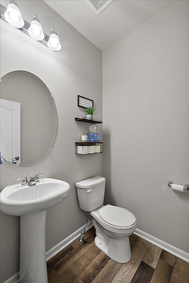 bathroom with wood-type flooring, sink, and toilet