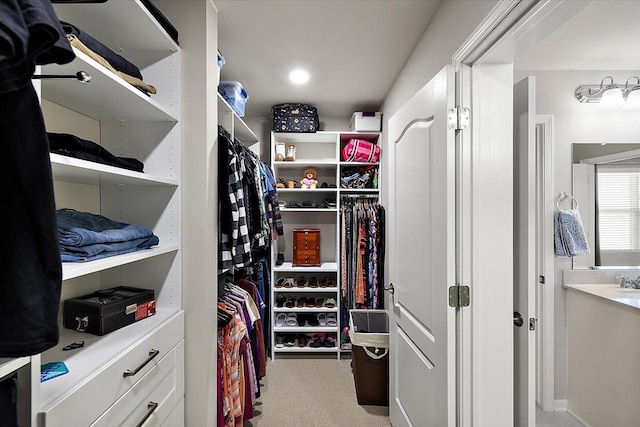 walk in closet featuring light carpet