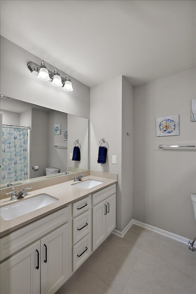 bathroom with tile patterned flooring, vanity, and toilet