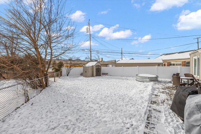 yard layered in snow featuring a shed