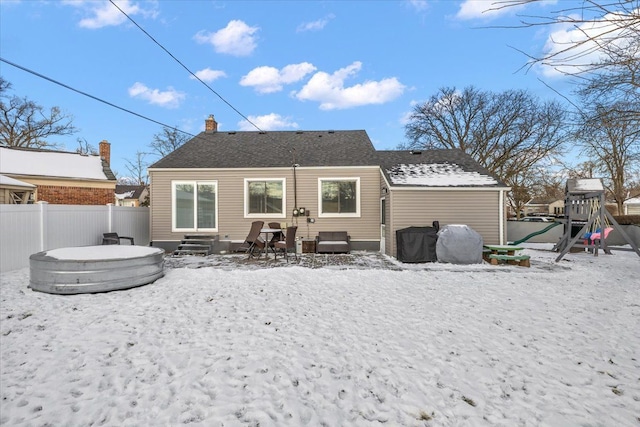 snow covered property with a playground and a hot tub