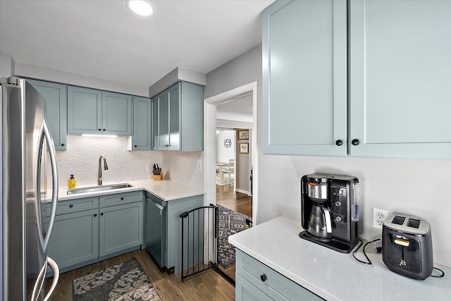 kitchen featuring sink, dark wood-type flooring, tasteful backsplash, and appliances with stainless steel finishes