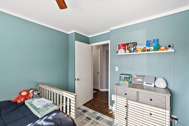 bedroom with dark hardwood / wood-style floors, ceiling fan, and ornamental molding