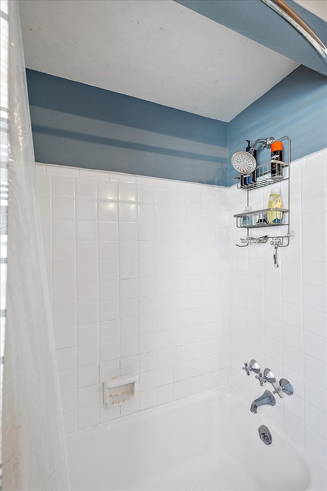 bathroom with shower / bath combination with curtain