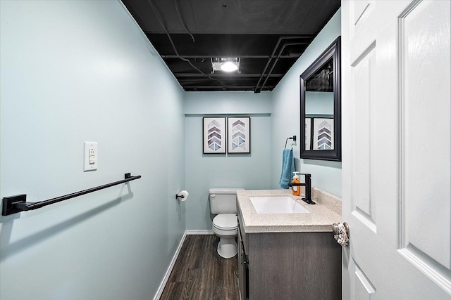 bathroom with wood-type flooring, toilet, and vanity