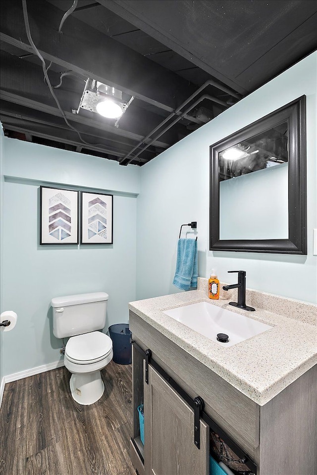 bathroom featuring vanity, toilet, and hardwood / wood-style floors