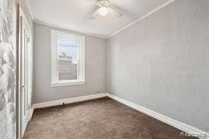 carpeted empty room featuring ceiling fan and crown molding