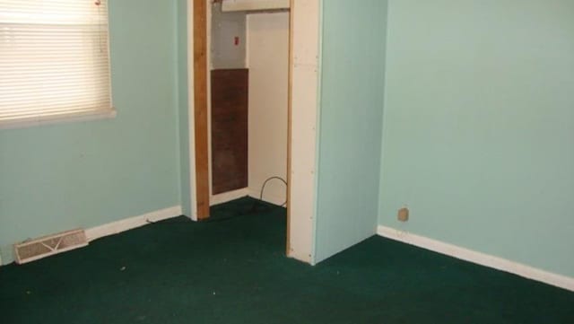 unfurnished bedroom featuring a closet and dark colored carpet