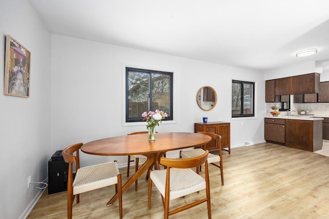 dining space featuring sink and light wood-type flooring