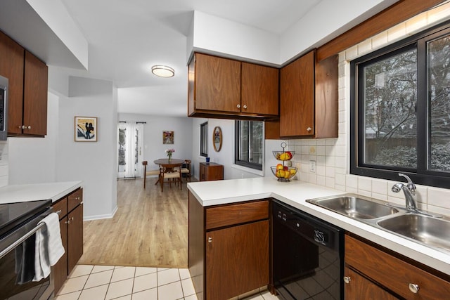 kitchen featuring black dishwasher, electric stove, backsplash, kitchen peninsula, and light wood-type flooring