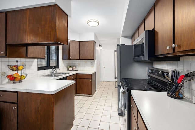 kitchen with sink, backsplash, light tile patterned floors, and stainless steel appliances