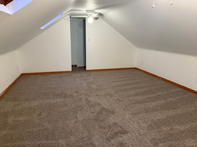 bonus room with carpet floors, lofted ceiling with skylight, visible vents, and baseboards