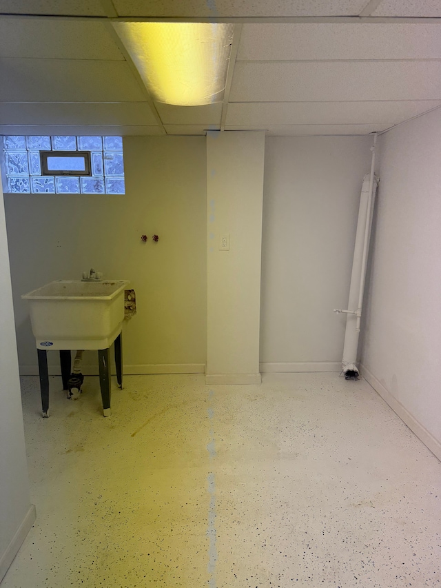 bathroom featuring a drop ceiling and baseboards