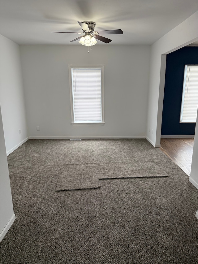 spare room with carpet, ceiling fan, and baseboards