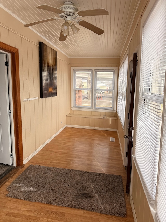 unfurnished sunroom with wood ceiling, visible vents, and a ceiling fan