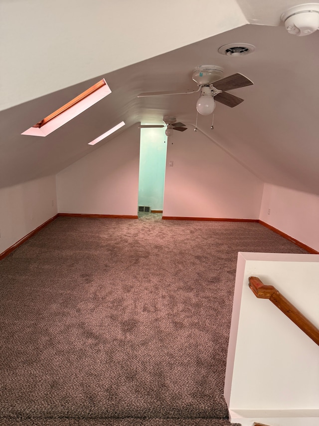 additional living space with lofted ceiling with skylight, baseboards, visible vents, and carpet flooring