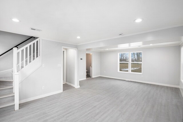 unfurnished living room featuring light wood-type flooring and ornamental molding