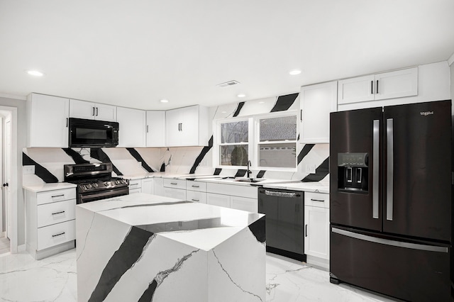 kitchen featuring white cabinets, black appliances, and a center island