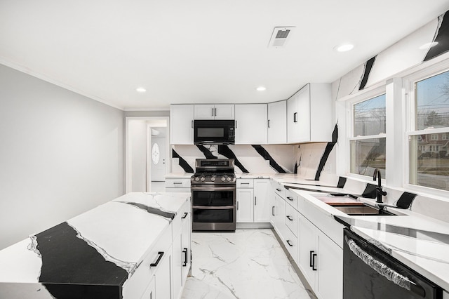 kitchen featuring black appliances, backsplash, white cabinetry, and sink