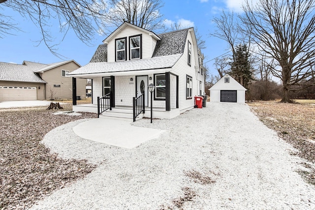 view of front of house featuring a garage, an outdoor structure, and covered porch