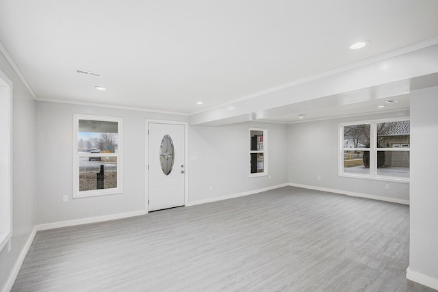 entrance foyer with light hardwood / wood-style floors and crown molding