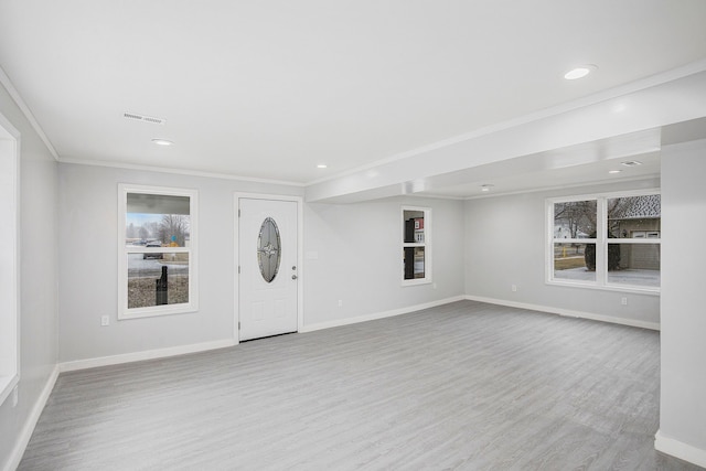 entryway with visible vents, crown molding, baseboards, and wood finished floors