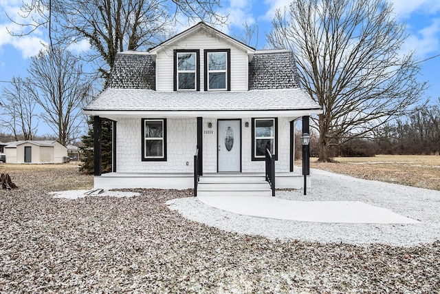 view of front of home featuring a porch and a storage shed