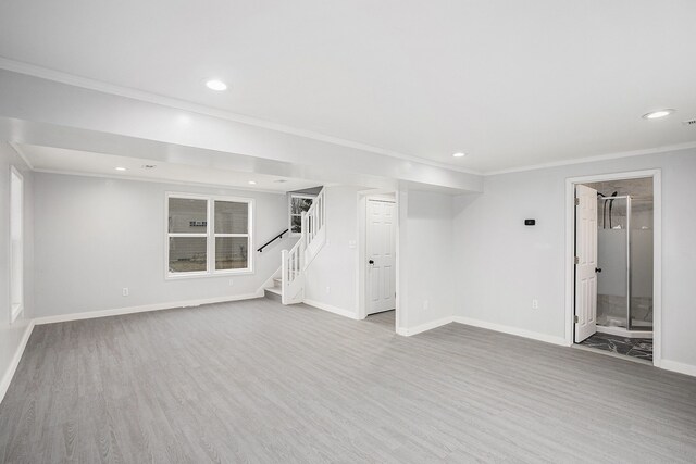 basement featuring crown molding and light hardwood / wood-style floors